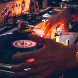 Hands working a record player, bright lights