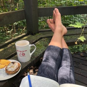 Feet propped up on a bench, coffee mug