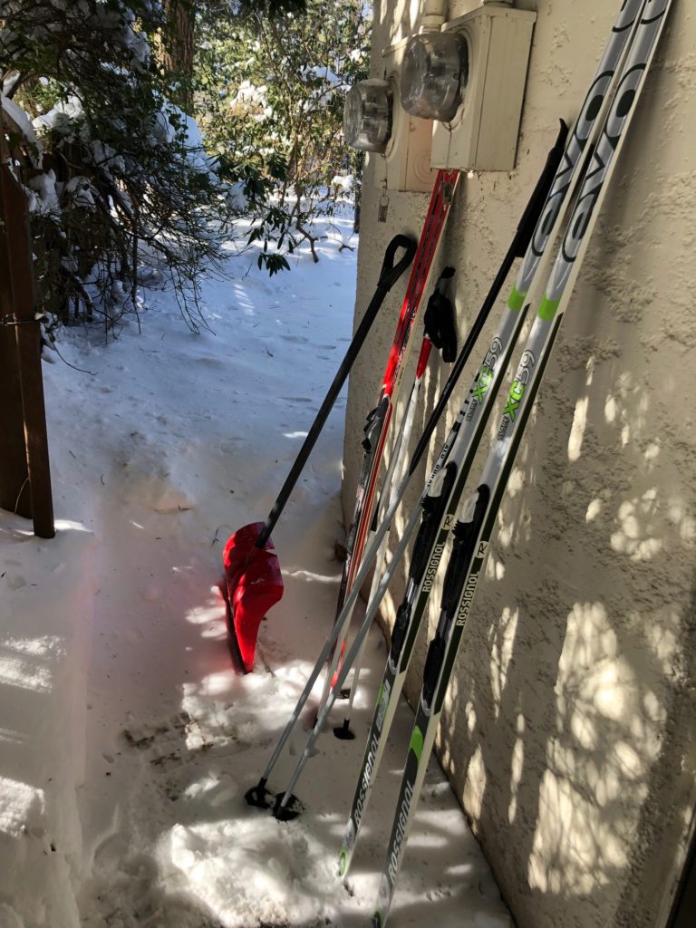 skis leaning against a wall; snow