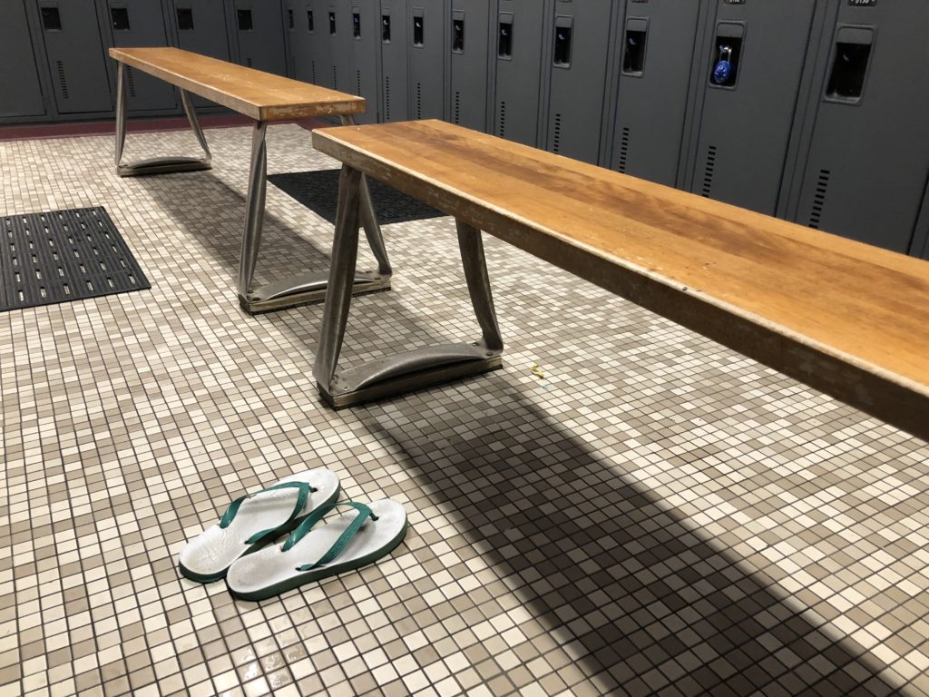 Plastic sandals on a tiled floor; lockers nearby