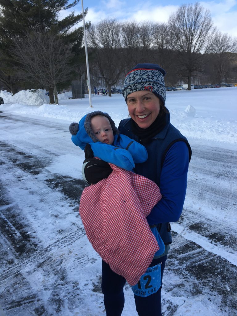 person holding a baby wearing a blue snow suit