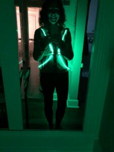 Person in the dark, wearing a glowing green vest