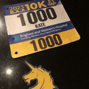 A race bib bearing the number 1000 near a unicorn sticker