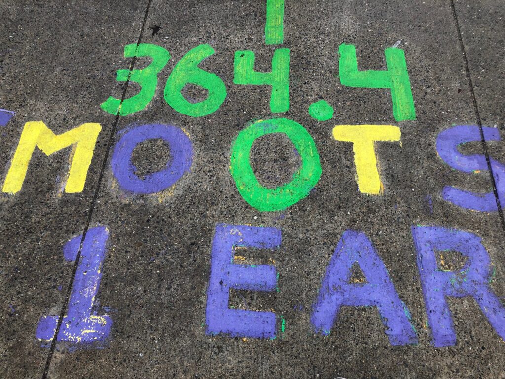 Text painted on cement in purple, green and yellow: 364.4 SMOOTS 1 EAR