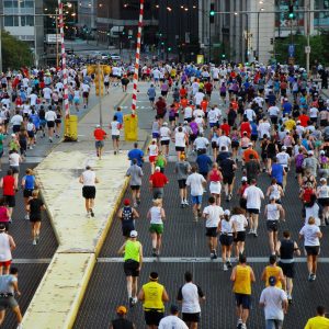 Several hundred runners heading away from the camera, up a wide city street